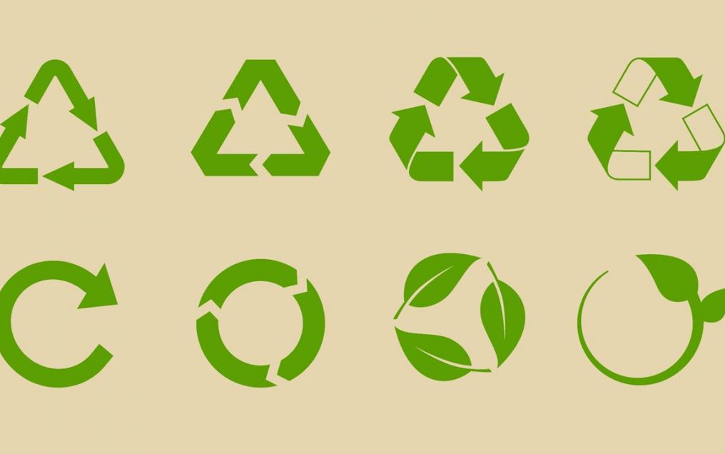 Différents logos de recyclage verts sur fond beige